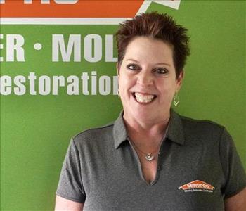 Photo of a woman named Ange Schroeder in front of the Servpro Logo